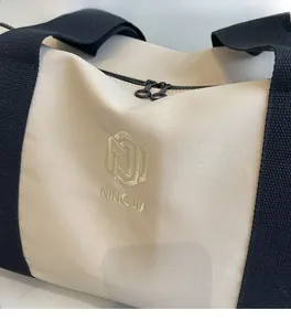 Dettaglio del tessuto in tela beige con ricami dorati di qualità e chiusure lampo