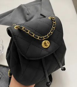Detail van zwarte gewatteerde mini-rugzak met gouden metalen ketting en draaisluiting