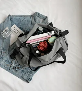 Macro detail of the spacious gray travel bag interior holding a bottle, umbrella and books