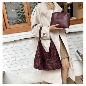 Detail of leopard print tote bag with wine red inner pouch showing textures and scale