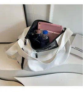 Interior view of large capacity white travel bag showing storage for tablet and bottle
