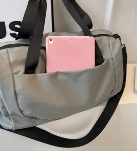 Detail view of the durable side pocket on the grey travel bag holding a tablet