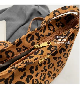 Dettaglio della cerniera in metallo dorato su una borsa a secchiello leopardata