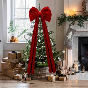 Gros plan d'un grand nœud de Noël en velours rouge dans un décor de fête chaleureux