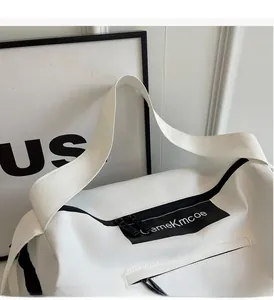 Close-up of white canvas travel bag featuring durable handles and black zipper pocket