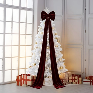 Détail macro d'un nœud géant en velours bordeaux sur un sapin de Noël blanc décoré
