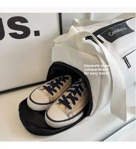 Detail of the white travel duffel bag showing a dedicated side compartment for shoes