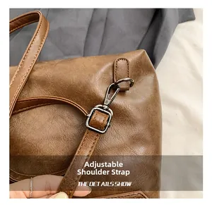 Detail view of the adjustable brown leather strap with gunmetal buckle and spring hook