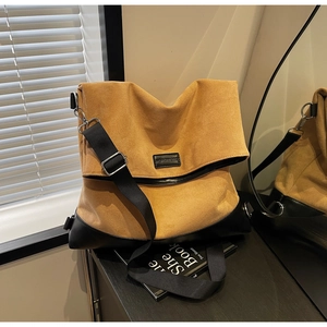 Detail of khaki suede and black leather bag with wide adjustable shoulder strap