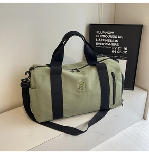 Dettaglio della borsa fitness verde chiaro con logo NINGJIA e tracolla nera regolabile
