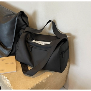 Detail of black gym bag on stone base featuring multiple zippers and nylon texture