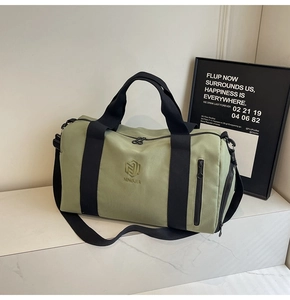 Dettaglio della borsa da palestra verde salvia con cinghie nere e tasca con zip