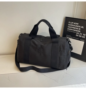 Dettaglio borsa fitness nera con manici rinforzati, tracolla e logo NINGJIA impresso