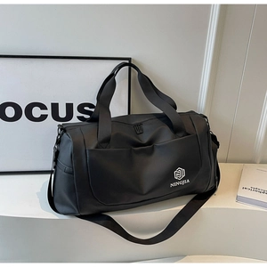 Detail of black waterproof travel bag with reinforced handles and NINGJIA logo