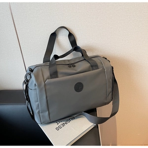 Dettaglio di borsa da viaggio grigio scuro in nylon resistente con logo in gomma