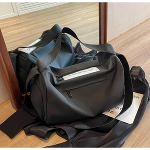 Detail of black gym bag with logo and multiple functional zipper pockets for travel
