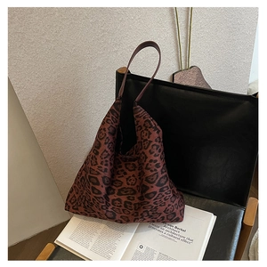 Detailed close-up of leopard print fabric and stitching on a large tote bag