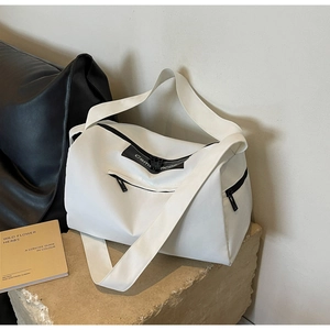 Detailed view of the durable black zipper and front pocket on white sports gym bag