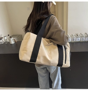 Dettaglio borsa fitness beige con cinturini neri e logo NINGJIA in un ambiente da caffetteria