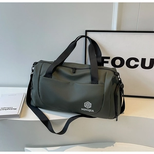 Close-up of waterproof dark green duffel bag with durable straps on white podium