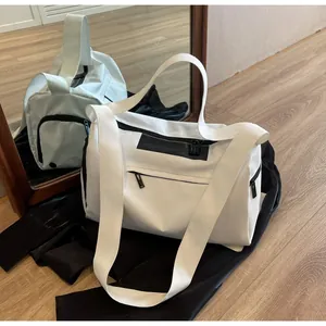 Detail of white large capacity sports gym bag showing durable nylon and black zippers