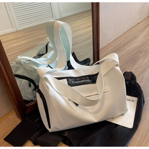 Detail of white nylon sports bag showing spacious main pocket and minimalist contrast design