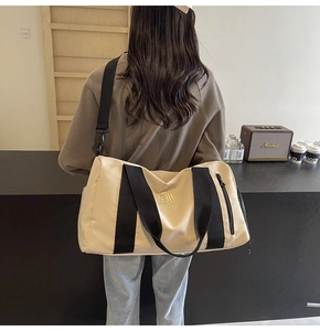 Vista posteriore di una borsa fitness beige capiente con ampie tracolle nere resistenti