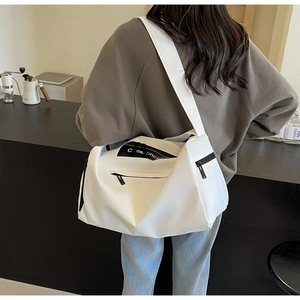 Detail view of large white canvas duffel bag with black straps and zip for travel or gym