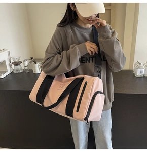Borsa fitness rosa con cinturini neri tenuta da una modella in un caffè moderno