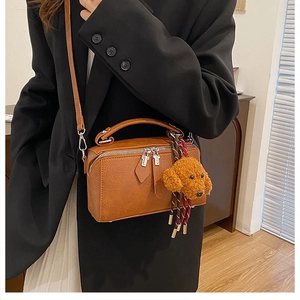 Gros plan d'un sac oreiller vintage avec zips argentés et charmant pendentif ours