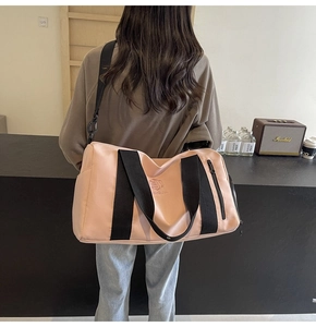 Borsa da viaggio fitness rosa con spalline nere indossata da una modella in interno