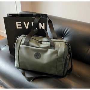 Dettaglio della borsa da viaggio con scomparto per scarpe su un divano in pelle nera