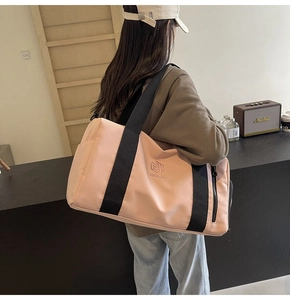 Borsone rosa da fitness con cinghie nere tenuto da una modella in un ambiente casual