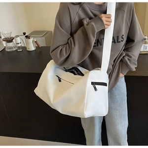 Detailed shot of white large capacity travel bag featuring branded letter print strap