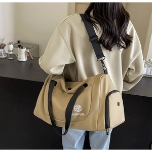Close-up of khaki travel bag showing side shoe compartment and adjustable black nylon strap