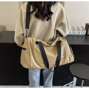 Side view of khaki travel bag showing shoulder strap and waterproof nylon texture