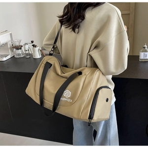 Detail of khaki travel bag with separate shoe compartment and adjustable shoulder strap