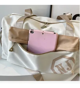 Détail de la poche avant zippée d'un sac de sport contenant une tablette pour la capacité