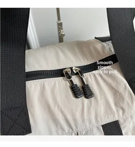 Détail du sac de voyage montrant les fermetures éclair fluides et le nylon robuste