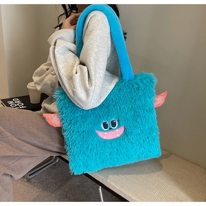 Détail du sac cabas monstre en peluche bleu vif avec visage brodé et texture douce