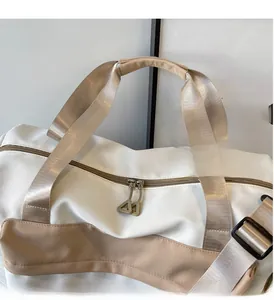 Détail des poignées renforcées et de la bandoulière réglable du sac de fitness