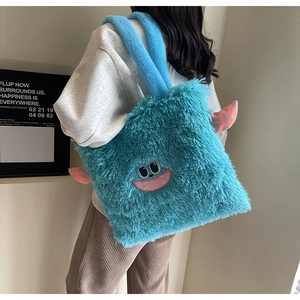 Détail du sac cabas monstre en peluche bleue avec des cornes orange sur l'épaule