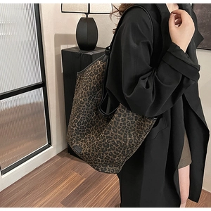Large leopard print tote bag shown on model with black trench coat for chic commuting look