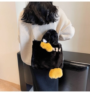 Détail d'un mignon sac pingouin en peluche noire avec bandoulière élégante en chaîne dorée