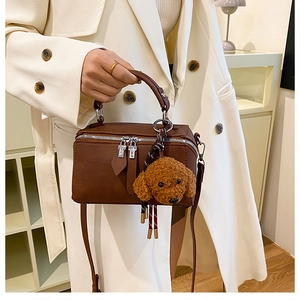 Sac Boston en cuir marron avec double fermeture éclair et breloque chien en peluche