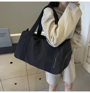 Dettaglio della borsa sportiva in nylon nero con ricamo NINGJIA e tasca laterale ampia
