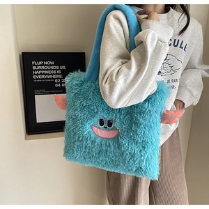 Détail du sac cabas en peluche bleue avec visage de monstre brodé et oreilles à pois