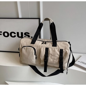 Détail du sac de sport beige avec poches cargo fonctionnelles et boucles réglables