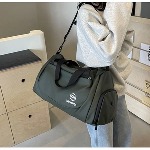 Close-up of a dark green travel bag with side zipper pocket and ventilated compartment