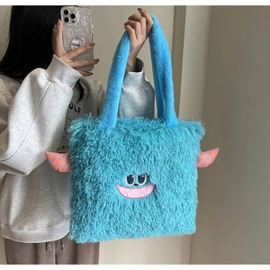 Détail d'un sac cabas en peluche monstre bleu avec broderie mignonne et cornes à pois roses